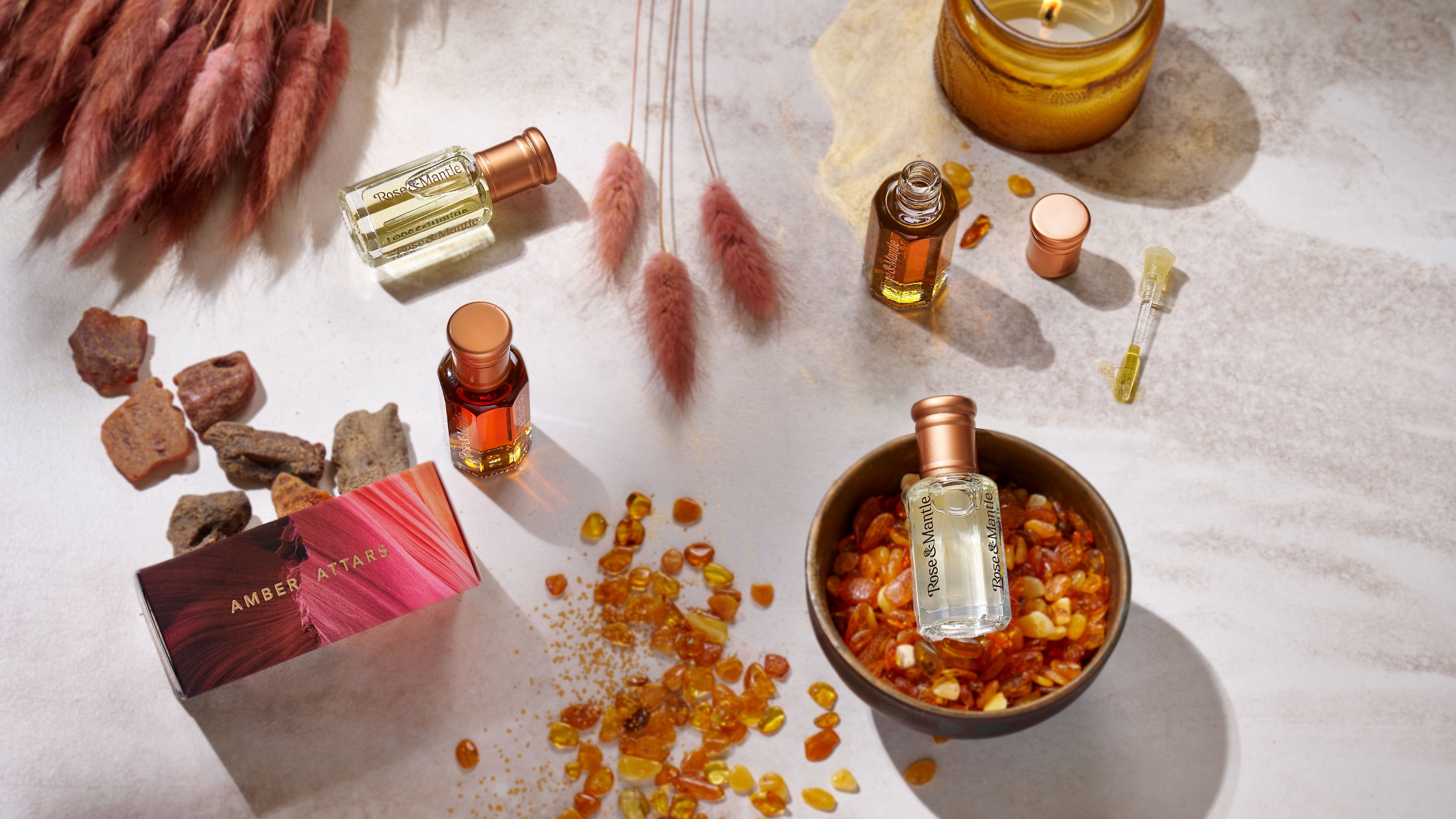 Rose & Mantle fragrances arranged with amber and botanical materials